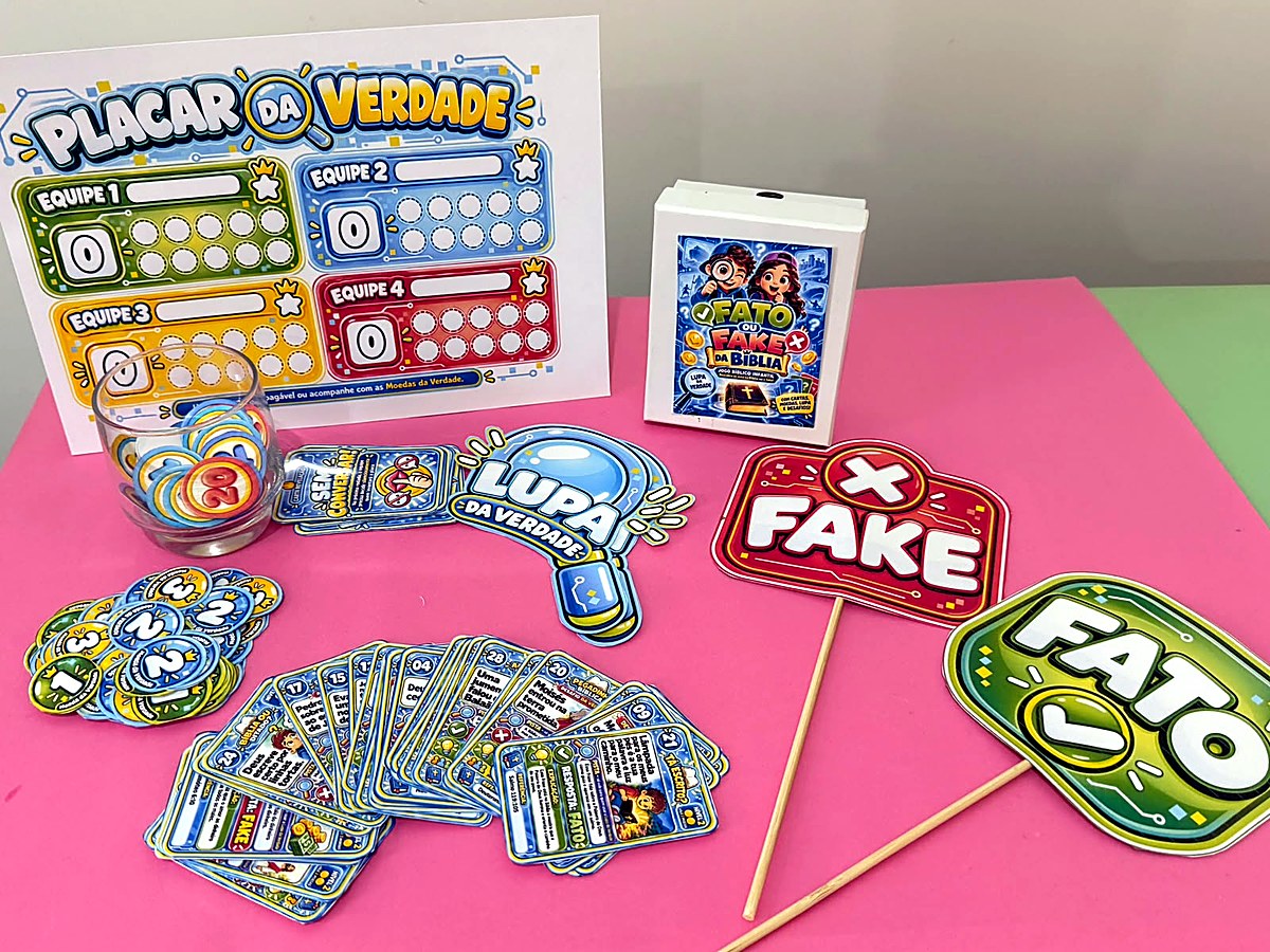 Foto real do kit completo montado na mesa: placar, caixinha, plaquinhas, Lupa da Verdade, moedas em um copo de vidro e cartas em leque